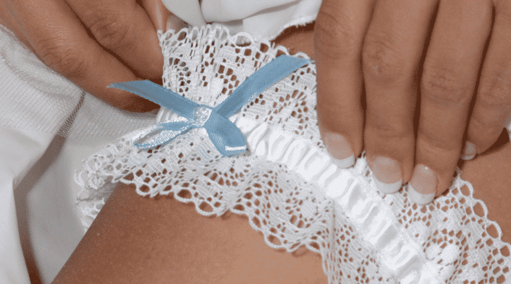 Meine Hochzeit. Mein Tag. Weißes Strumpfband mit einer kleinen blauen Schleife als Zeichen für Hochzeitsbräuche.